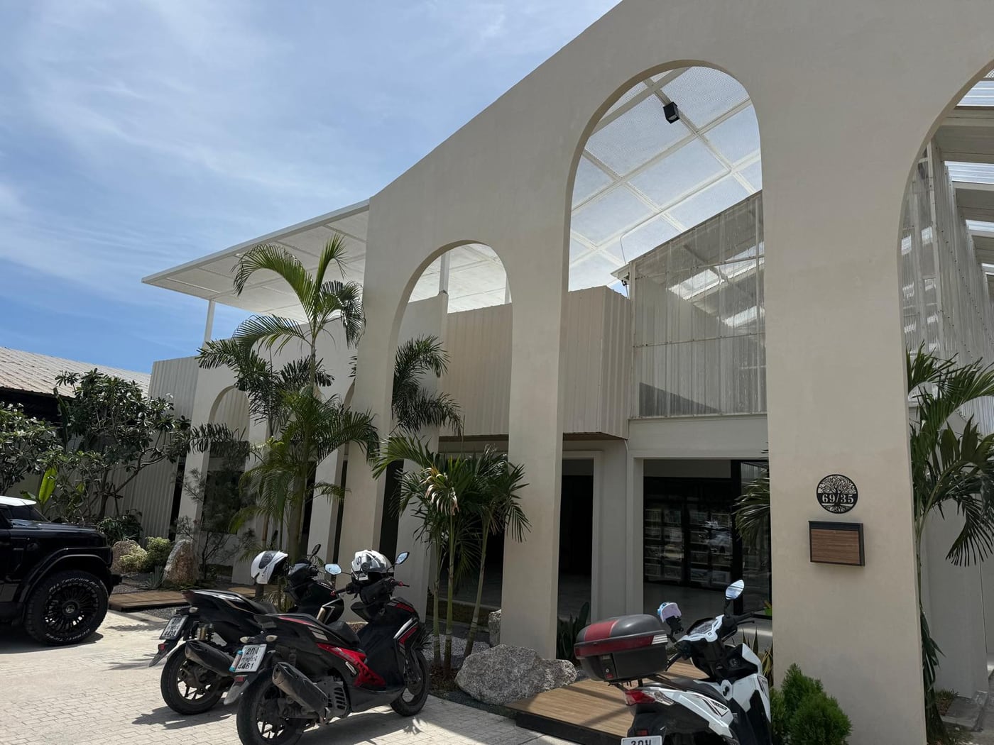 The Numena family office on Koh Samui, a white arched building surrounded by palms